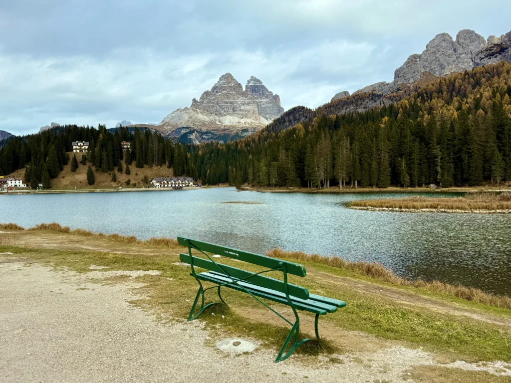 Bank mit Blick auf den Misurinasee und im Hintergrund die Drei Zinnen von Lavaredo im Oktober. Im Oktober gibt es nur wenige Touristen, und der Ort wird geradezu magisch.